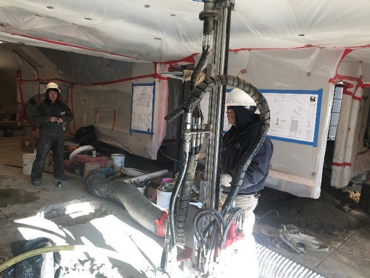 Park Range crew running a micropile drill rig inside a protected home at Anthem Ranch