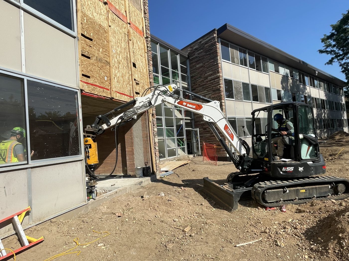 Park Range mini excavator installing a helical pile beneath an opening in the wall of Allison Hall at Colorado State University