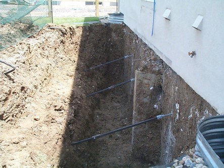 Helical tiebacks installed in a shored excavation along a home's foundation wall