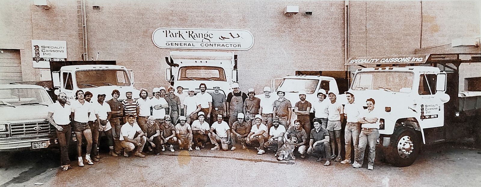 The early Park Range Construction crew lined up with their trucks outside the shop